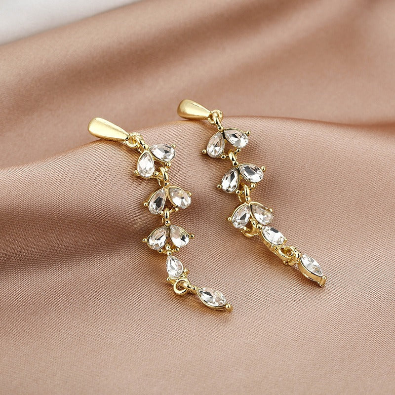 Pendientes hoja dorados con circonitas · Baño de oro 18K