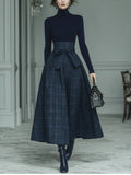Conjunto de punto azul oscuro con cuello alto y falda de cuadros